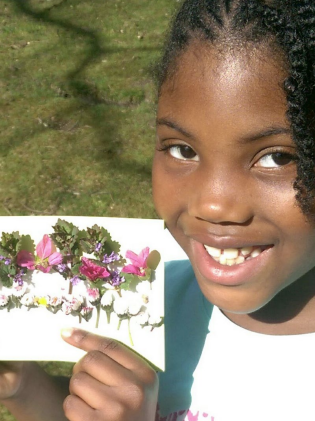 Student holding art made from leaves