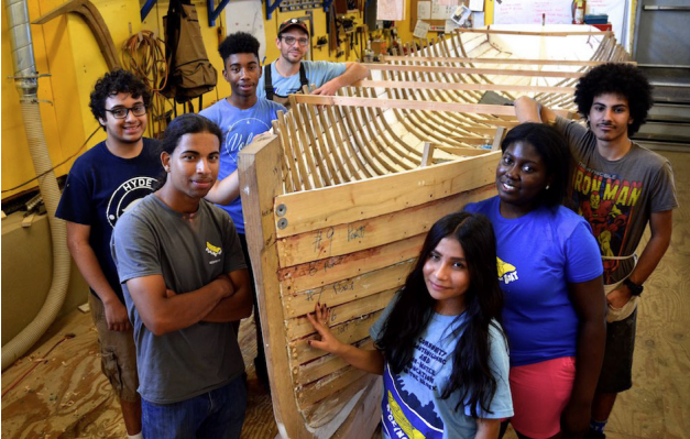 Kids standing by a hull of a boat