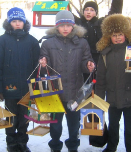 Kids holding birdhouses