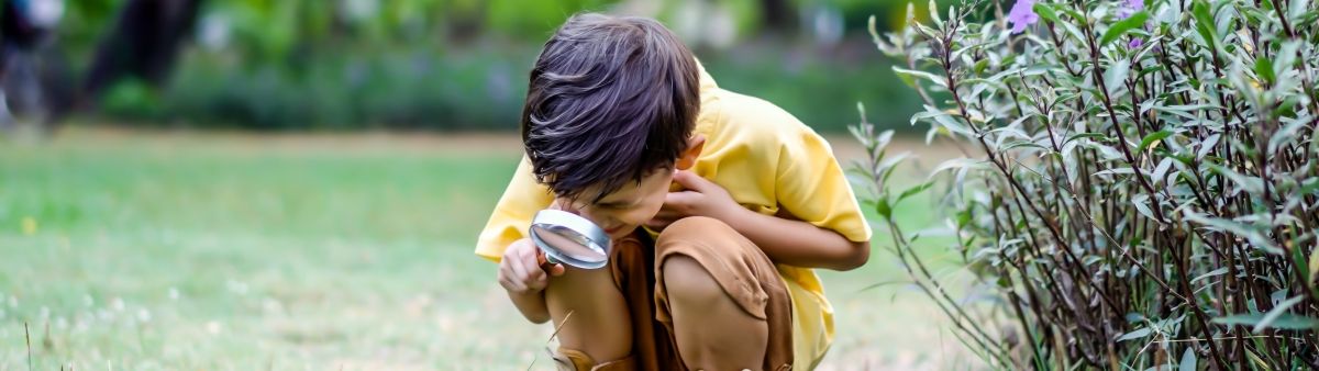 Kid with a magnifying glass outside