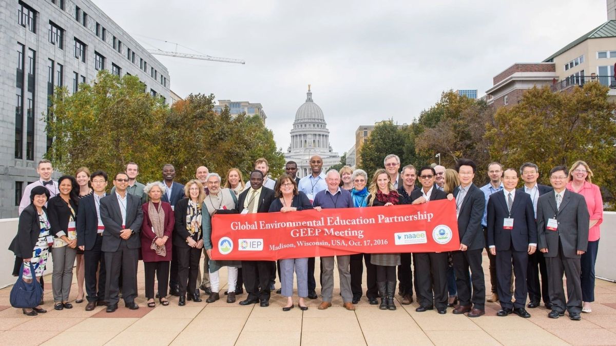 Group photo of GEEP Advisors in front of red banner.